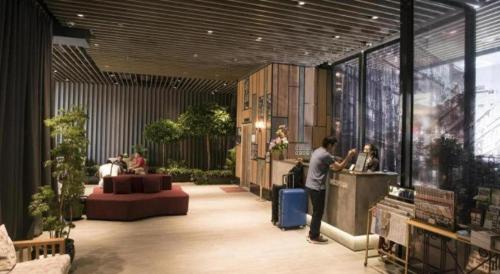 a man standing at a counter in a lobby at Largos Hotel in Hong Kong