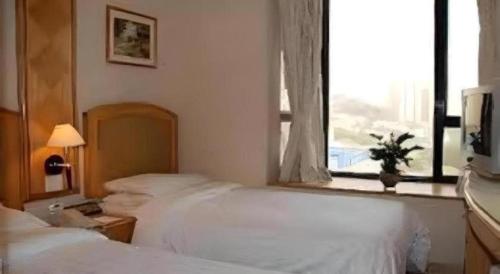 a bedroom with two white beds and a window at Largos Hotel in Hong Kong