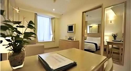 a hotel room with a table and a bedroom at Largos Hotel in Hong Kong