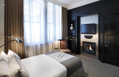 a hotel room with a bed and a fireplace at Fifteen Beacon Hotel in Boston