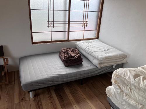 Ένα ή περισσότερα κρεβάτια σε δωμάτιο στο MOTORYOKAN Guesthouse & Cafe