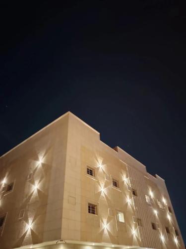 a building with lights on the side of it at غرفتين نوم وصاله دخول ذاتي in Quai