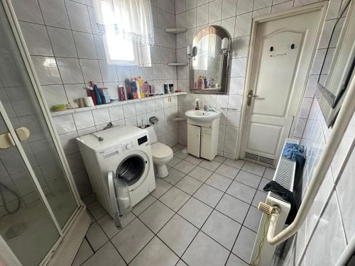 Un baño con lavadora y un inodoro. en Noclegi Bartodzieje 56, 