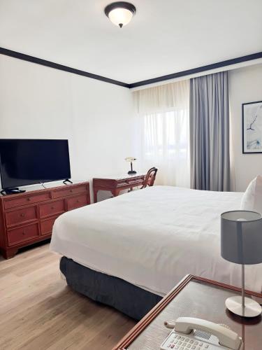 a hotel room with a bed and a flat screen tv at Radisson Colon 2,000 Hotel & Casino in Colón