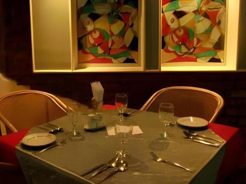 a table with glasses and silverware on top at Hotel Tower Inn, Chittagong in Chittagong