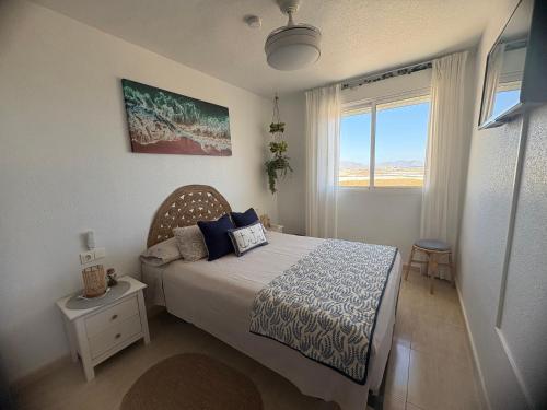 a bedroom with a bed and a window at Bright apartment with private terrace and sea views in Bolnuevo