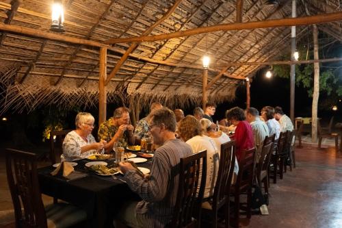 a group of people sitting at a table in a restaurant at Wild Wadi Wilpattu - Villas with private Plunge Pools in Wilpattu