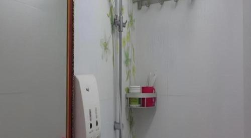 a white refrigerator freezer sitting next to a wall at New Mong Kok Guest House in Hong Kong