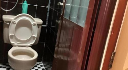 a bathroom with a toilet with the lid up at New Mong Kok Guest House in Hong Kong