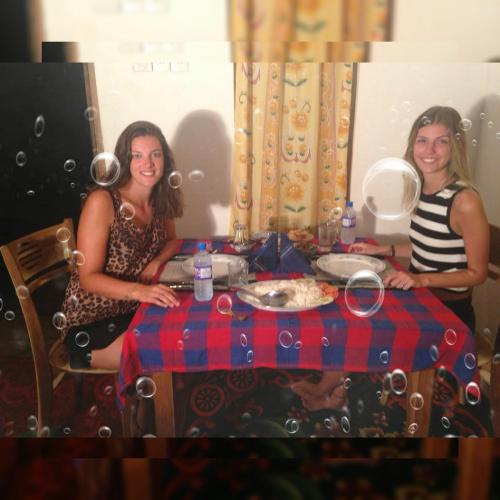 two women sitting at a table with a plate of food at Isanka Lion Lodge in Sigiriya