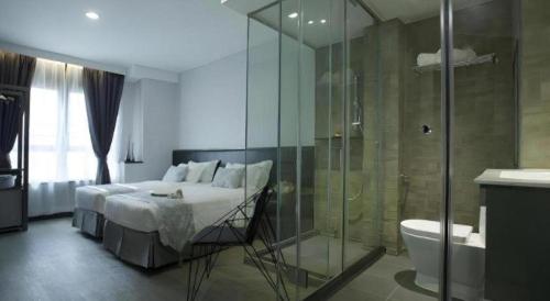 a bedroom with a bed and a glass shower at M1 North Point Hotel in Hong Kong