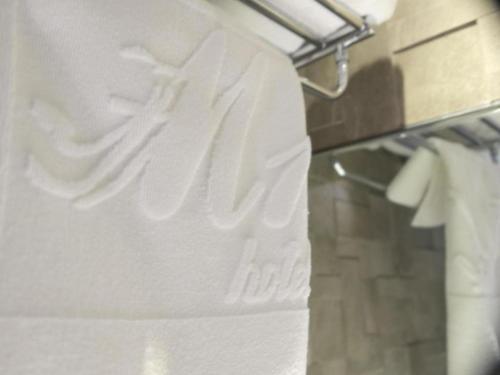 a towel rack with white towels in a bathroom at M1 North Point Hotel in Hong Kong