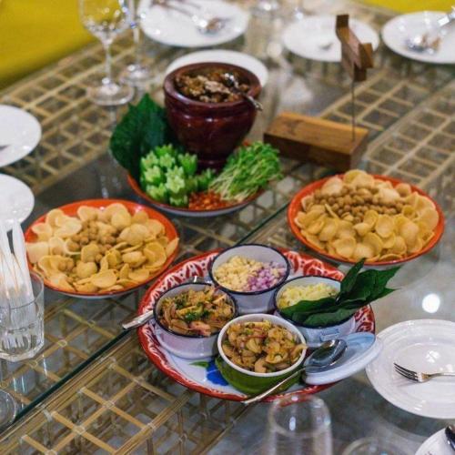 a table with many plates of food on it at The Buffalo Amphawa in Samut Songkhram