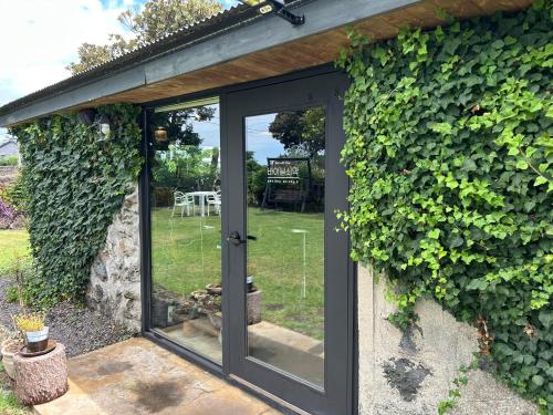 an entrance to a garden with a glass door at Imjingotaek Hanok Stay Jeju Traditional House LP Cozy House, Wagon stay at Imjingotaek in Jeju