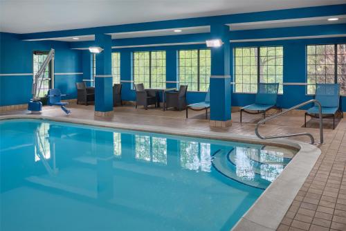 a swimming pool with chairs and tables in a building at Hampton Inn Kansas City The Legends in Kansas City