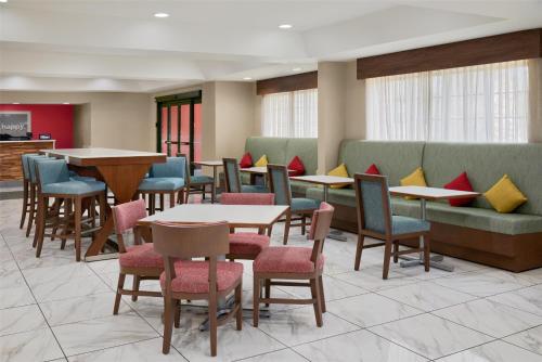 a waiting room with tables and chairs and a couch at Hampton Inn Kansas City The Legends in Kansas City