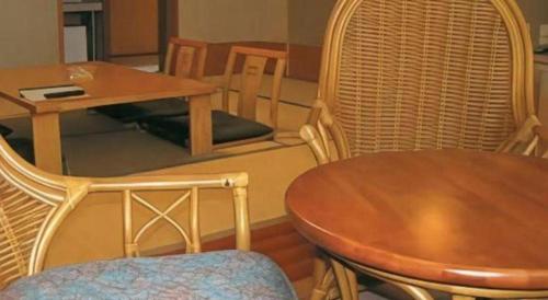 a table and chairs with a wooden table and a table and a table and chairs at Petit Hotel Hoshi no Shizuku in Kitashiobara