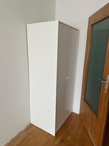 a white closet with a door in a room at WG Riedau in Riedau