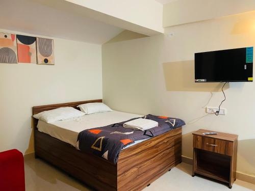 a bedroom with a bed and a flat screen tv at Zivo Stays, Studio Apartments, Jubilee Hills in Hyderabad