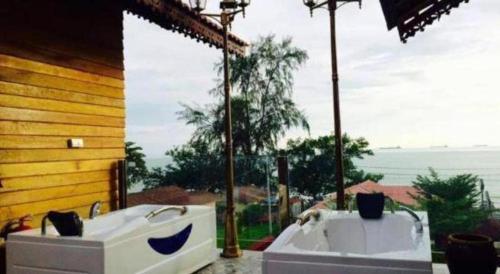 a bath tub sitting on top of a porch at Kampong Pinang Sebatang Melaka in Melaka
