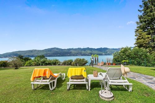 a group of three lawn chairs sitting on the grass at Casa Malpensata - Happy Rentals in Porto Valtravaglia