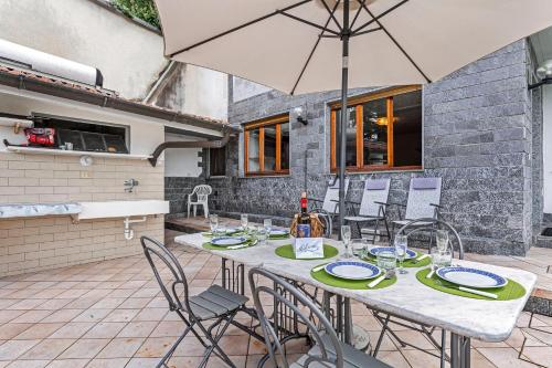 a table with chairs and an umbrella on a patio at Casa Malpensata - Happy Rentals in Porto Valtravaglia