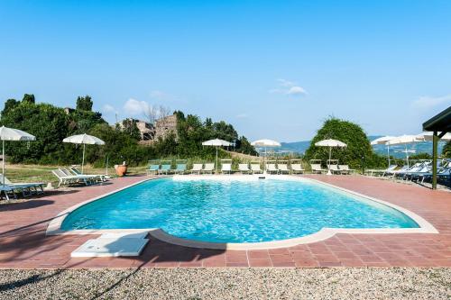 uma grande piscina com cadeiras e guarda-sóis em Borgo Cerbaiola em Montecastelli