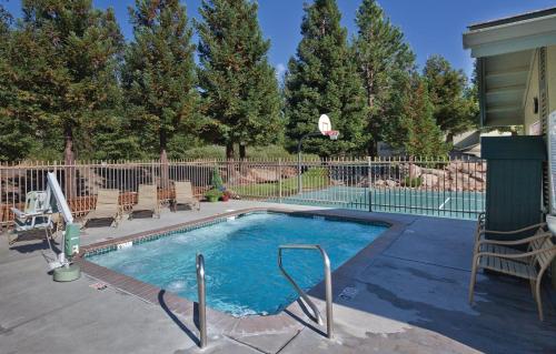 a swimming pool in a yard with chairs and a fence at WorldMark Bass Lake in Bass Lake