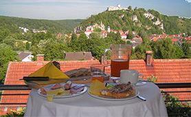 - une table avec deux assiettes de nourriture et une boisson dans l'établissement Pension Im Malerwinkel Kallmünz, à Kallmünz