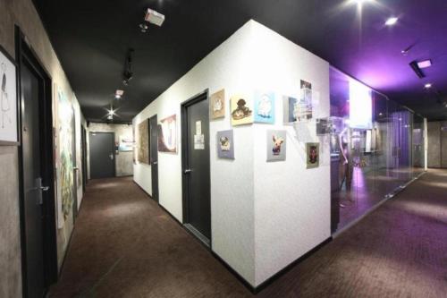 a hallway in a building with pictures on the wall at The Hulo Hotel & Gallery in Kuala Lumpur
