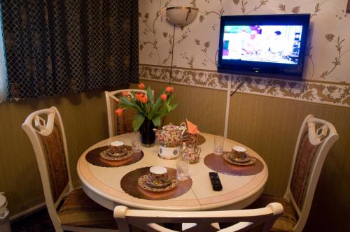 a dining room table with a television and a table and chairs at Weena House in Rotterdam