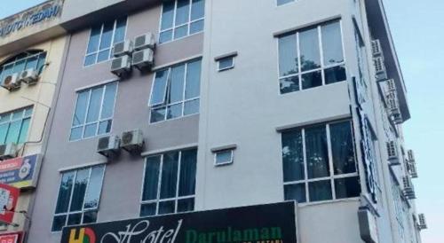 a tall building with a sign in front of it at Hotel Darulaman Alor Setar in Alor Setar