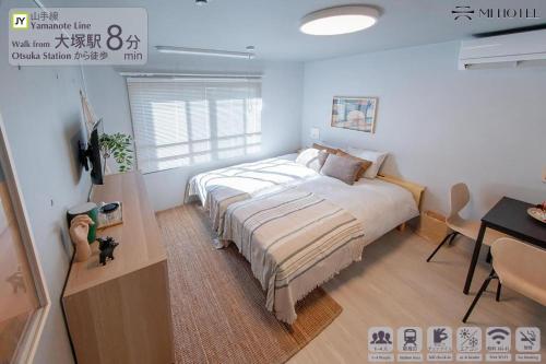 a bedroom with a bed and a desk with a computer at Mi-HOTEL OTSUKA in Tokyo