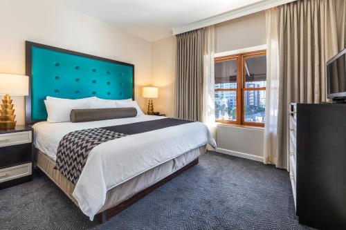 a hotel room with a bed and a television at WorldMark San Diego - Balboa Park in San Diego