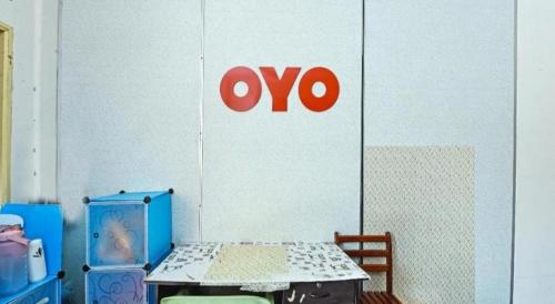 a room with a table and ayo sign on a wall at OYO 90315 Chalet Pantai Rantau Panjang in Kuala Rompin