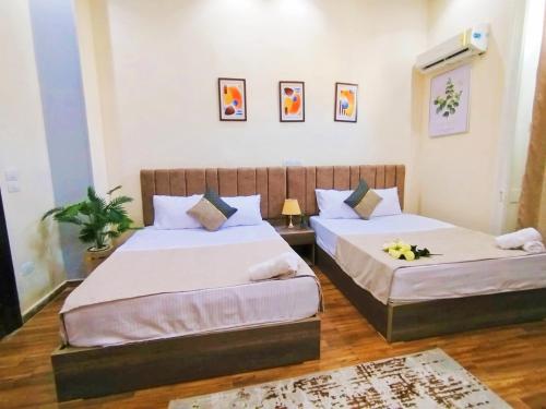 two beds in a hotel room with flowers on them at Royal central home Cairo in Cairo