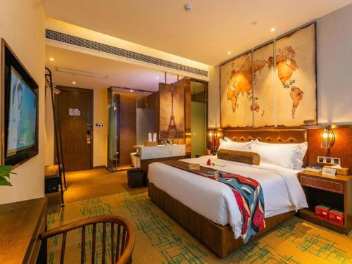 a hotel room with a large bed and a television at James Joyce Coffetel Chengdou Wuqing Wanda Plaza in Chengdu