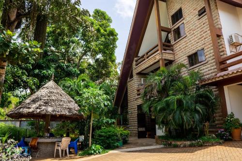 an exterior view of a building with a thatch roof at Mtwapa Curtie Home in Mombasa