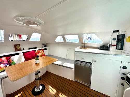 Una pequeña cocina con una mesa de madera en un barco. en Séjour sur un catamaran, paddle et snorkeling, en Orufara