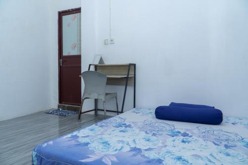a bedroom with a bed and a desk and a chair at Rumah Nusantara in Sengkol