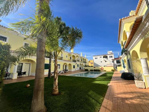 a courtyard with palm trees and a swimming pool at Rockfield 4 in Albufeira