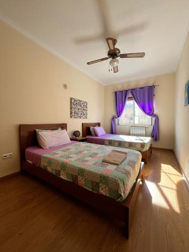 a bedroom with two beds and a ceiling fan at Rockfield 4 in Albufeira