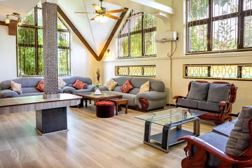 a living room with couches and tables and windows at Mtwapa Curtie Home in Mombasa