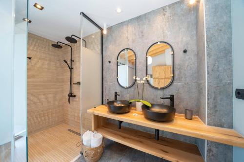 a bathroom with two sinks and two mirrors at Villa Drogarati Cottage by Villa Plus in Chaliotata