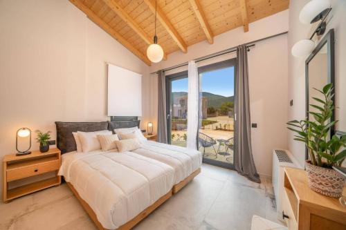 a bedroom with a large bed and a large window at Villa Drogarati Cottage by Villa Plus in Chaliotata