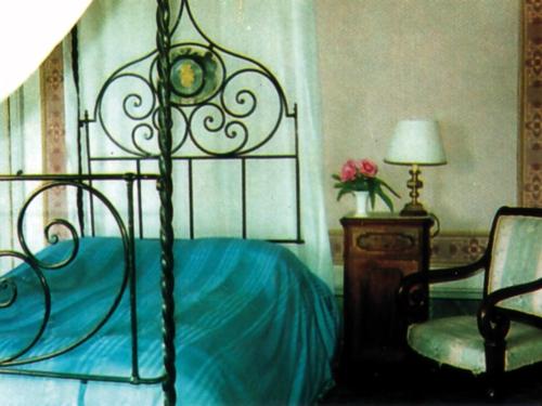 a bedroom with a bed and a chair and a lamp at Fattoria Di Cavaglioni in San Rocco a Pilli