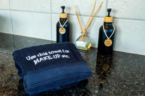 two bottles of wine on a counter with a towel at 7th Hole Golf Lodge in Modimolle