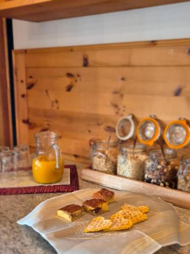 a table with a plate of food and orange juice at Lienharterhof in Monguelfo