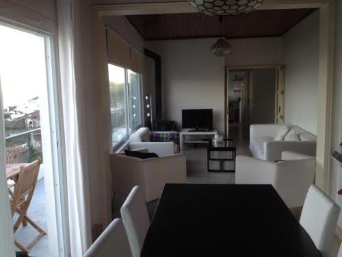 a living room with a black table and white chairs at Sea Bay House in Lagoa