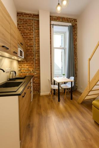 a kitchen and dining room with a table and a window at Gdańska 44 Apart in Łódź